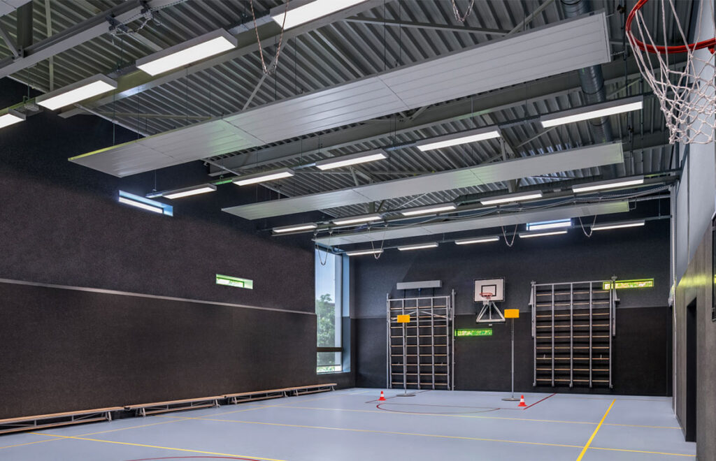 Sporthallstak med flera långa, upphängda och infällda LED-armaturer från PROLJUS AB som ger jämnt, bländfritt och energieffektivt ljus för idrottsytor, robust design för hög takhöjd och enkel installation som förbättrar sikt och minskar driftkostnader