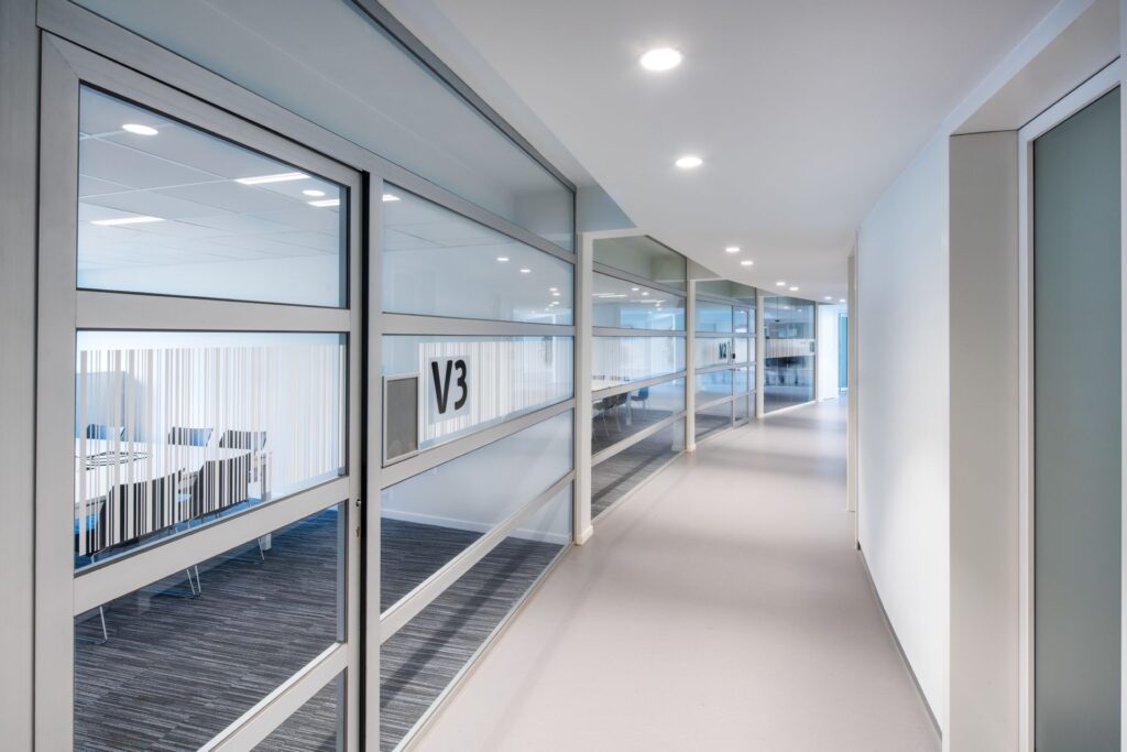 Ljus kontorskorridor med infällda takarmaturer som ger jämnt och bländfritt arbetsljus, energieffektiva och stilrena lösningar från PROLJUS AB idealiska för moderna kontorsmiljöer