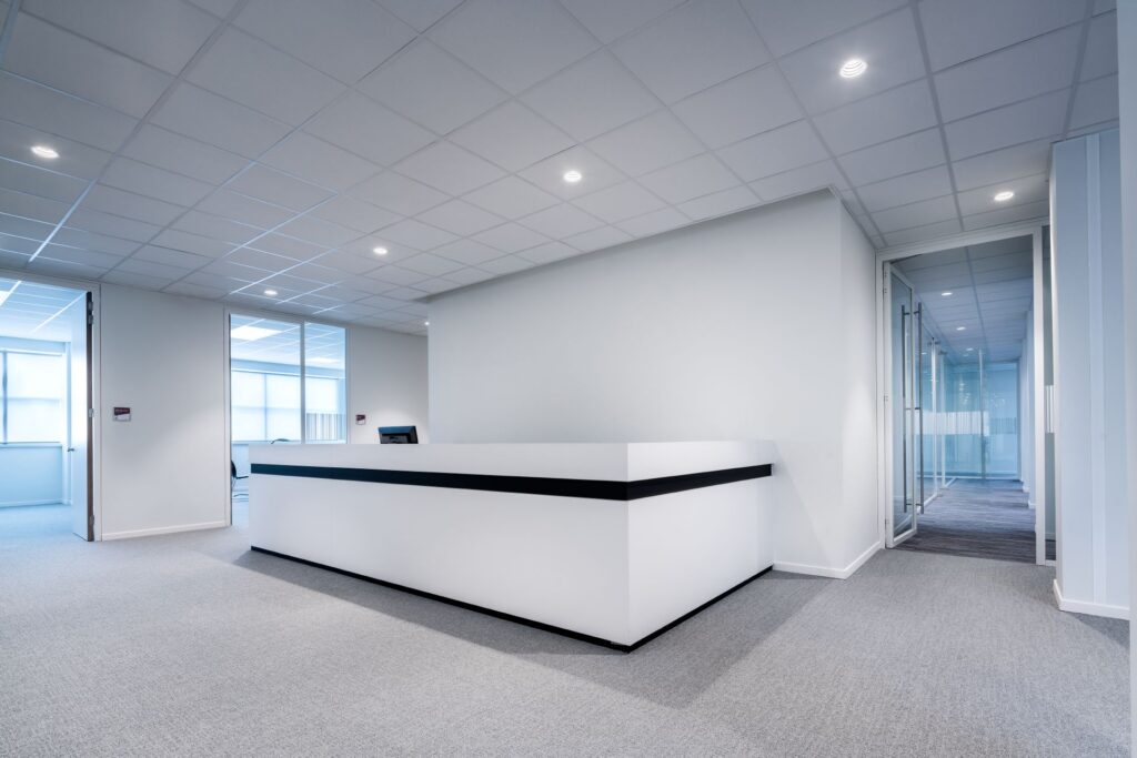 Kontorsreception med inbyggda LED-downlights i undertaket som ger jämnt, bländfritt och energieffektivt ljus som framhäver modern inredning och skapar professionell arbetsmiljö från PROLJUS AB