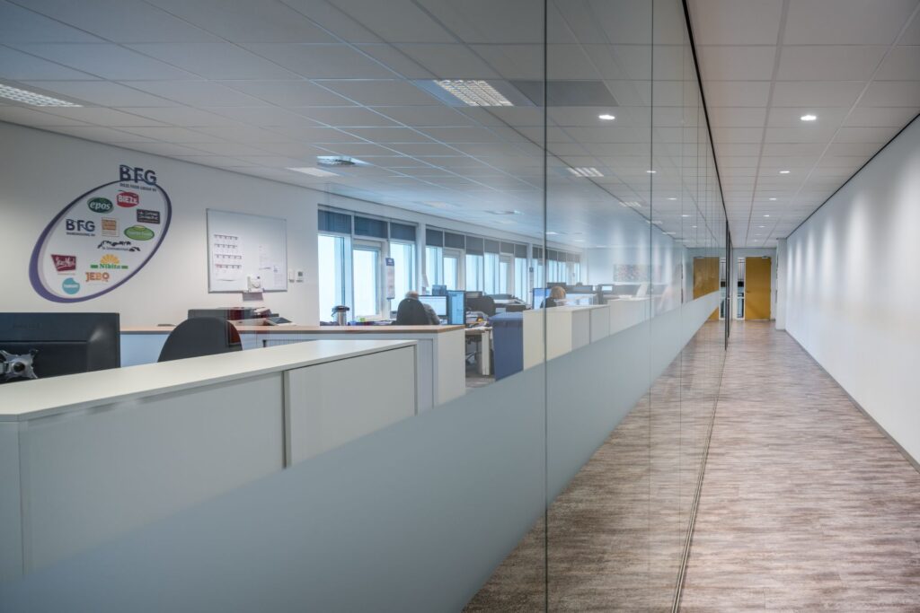 Öppet kontor med jämnt fördelade infällda LED-armaturer och takspotlights som ger bländfri, energieffektiv arbetsbelysning och förbättrad produktivitet, kontakta PROLJUS AB för skräddarsydda kommersiella belysningslösningar