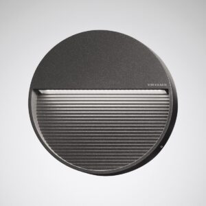 Rund mörkgrå väggarmatur i metall med horisontell LED‑öppning och ribbad nedre yta, energieffektiv modern design från PROLJUS AB som ger mjuk riktad belysning för både inomhus och utomhus