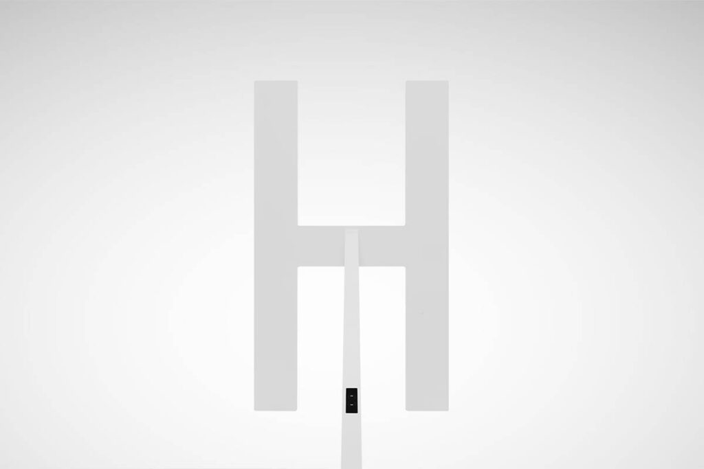 Slimmad H-format LED-armatur i vit minimalistisk skandinavisk design från PROLJUS AB, med jämnt energisnålt ljus och diskret monteringsstolpe, perfekt för kontor och kommersiella miljöer, kontakta PROLJUS AB för offert