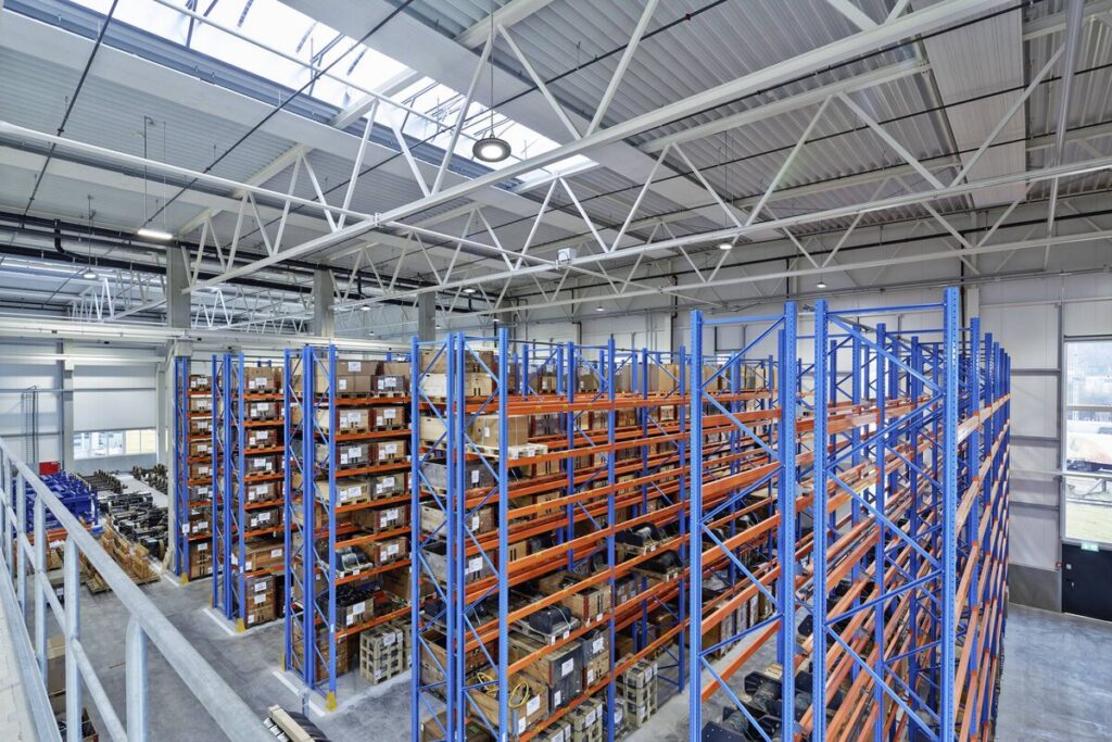 Stort industrilager med högt tak och flera energieffektiva hängande LED-armaturer från PROLJUS AB som ger jämnt, kraftfullt arbetsljus och lägre energikostnader