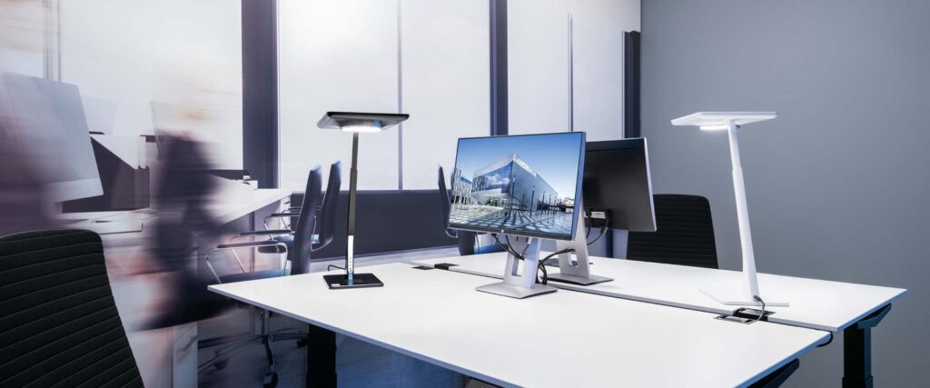 Modernt kontorslandskap med två höjdjusterbara energieffektiva LED-armaturer från PROLJUS AB som levererar jämnt bländfritt arbetsljus och skandinavisk design som ökar komfort och produktivitet