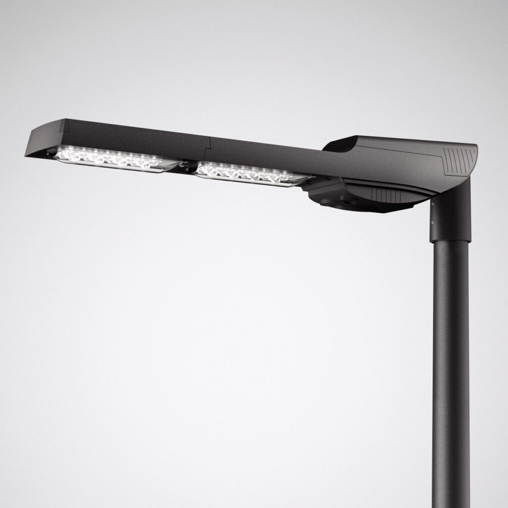 Elegant och kompakt dubbelluminär i mörkgrå aluminium med två kraftfulla LED‑moduler monterad på stolpe, energieffektiv och med lång livslängd från PROLJUS AB, modulär design för enkel installation och intelligent ljusstyrning, perfekt för gator, parker och urbana miljöer