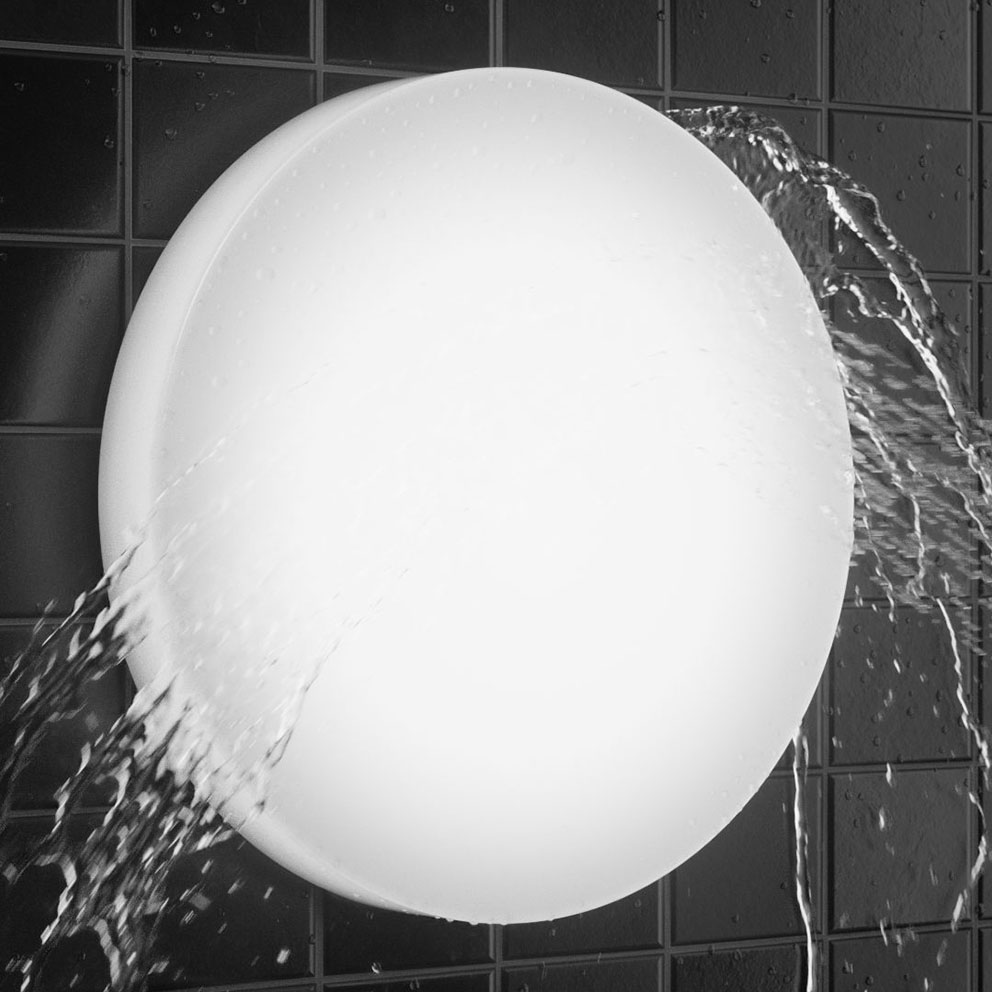 Rund väggmonterad armatur som avger mjukt, jämnt ljus mot kakel medan vatten forsar över ytan, visar funktionell, modern och vattentålig design för våtutrymmen från PROLJUS AB