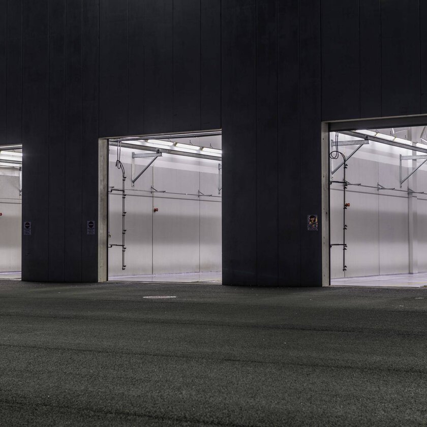 Energieffektiva LED-armaturer från PROLJUS AB lyser upp tre öppna garageportar med jämnt, kraftfullt vitt ljus som framhäver rena ytor och modern industriell estetik perfekta för företag som vill sänka driftkostnader och förbättra arbetsmiljön