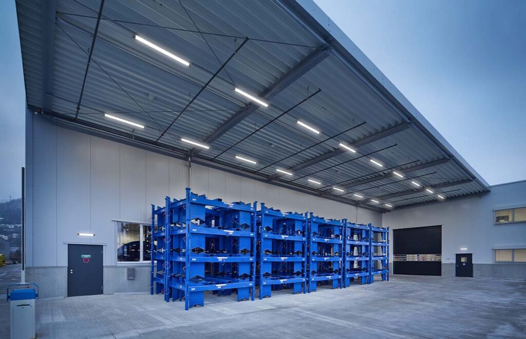 Exteriört industriområde upplyst av PROLJUS ABs vädertåliga linjära LED-armaturer monterade i undertak, som ger stark, jämn och bländfri belysning över stora ytor, sparar energi och förbättrar säkerhet och produktivitet i lager och logistikanläggningar