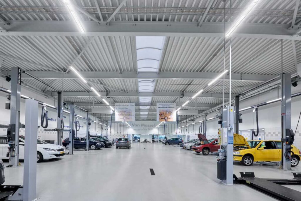 Ljusstarka lineära LED-armaturer från PROLJUS AB lyser upp en rymlig bilverkstad med jämn, skuggfri arbetsbelysning och naturliknande färgåtergivning, energieffektiva industrilösningar som förbättrar säkerhet, produktivitet och minskar driftskostnader