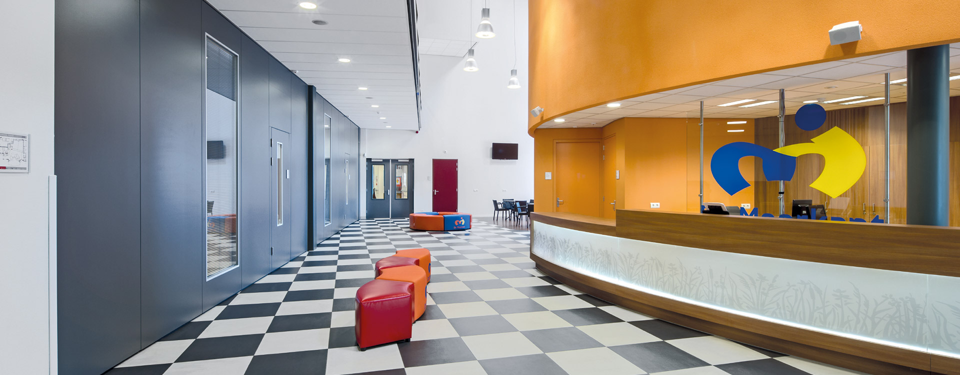 Ljusstark modern entréhall upplyst av PROLJUS AB:s eleganta takpendlar, infällda downlights och väggmonterade spotlights som ger jämn energieffektiv belysning och framhäver färgerna i mottagningen, idealiskt för kommersiella miljöer och visningsutrymmen