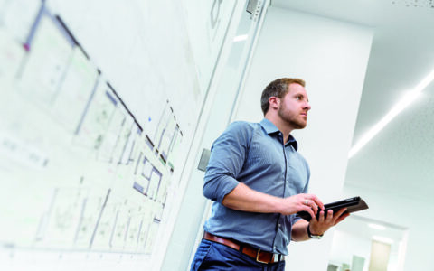 Man i modernt kontor upplyst av linjära LED-armaturer och infällda spotlights som skapar klart och energieffektivt arbetsljus perfekt för kontor och visar PROLJUS ABs eleganta belysningslösningar