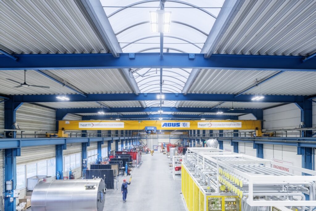 Väl upplyst industrilokal med rader av moderna LED-armaturer monterade längs valvtak och över produktionsgång, jämn och energieffektiv arbetsbelysning som ökar säkerhet och produktivitet och pålitliga belysningslösningar från PROLJUS AB