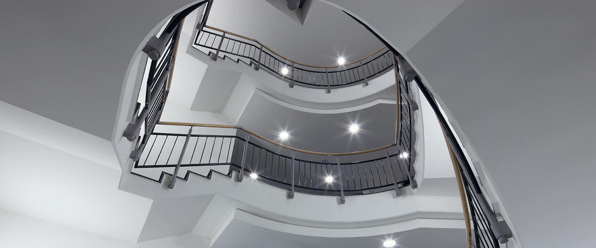 Trapphus sedd underifrån med flera infällda LED-armaturer som avger klart, jämnt och energieffektivt ljus med dekorativa stjärneffekter, perfekt för entréer och kontor, belysningslösningar från PROLJUS AB