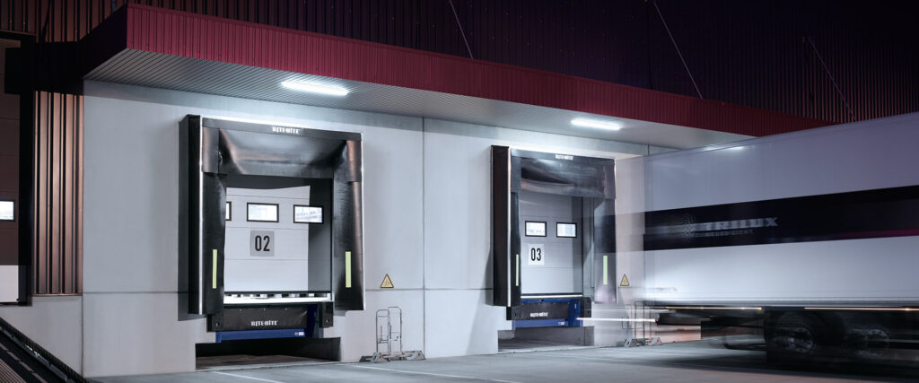 Nattbild av två industriella lastkajer belysta av moderna energieffektiva armaturer från PROLJUS AB som ger klart och jämnt vitt ljus över lastområdet, förbättrar säkerhet och sikt samt möjliggör kostnadseffektiv drift och lågt underhåll