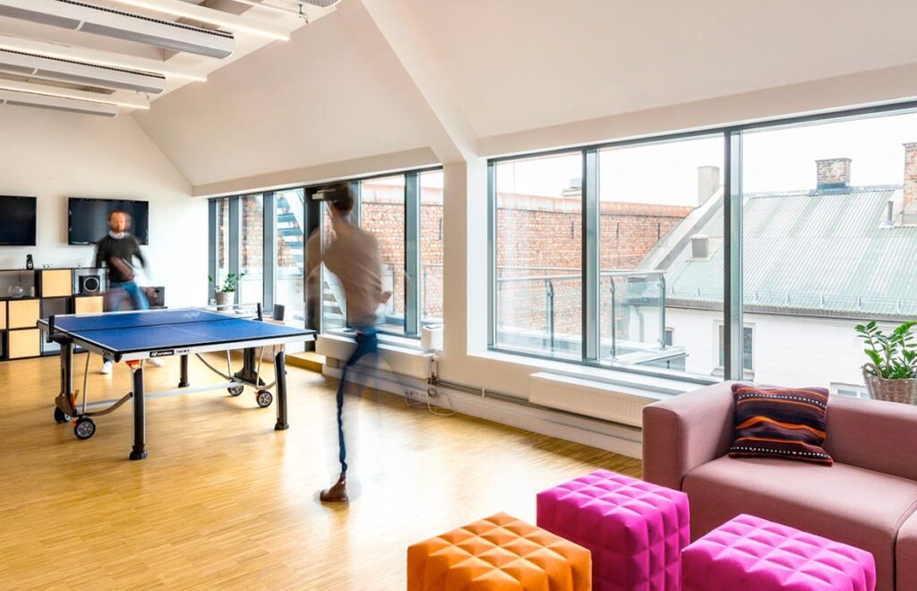 Slimmade linjära takarmaturer som sprider jämn och energieffektiv belysning i ett ljust modernt kontors- och loungeutrymme idealiskt för PROLJUS AB