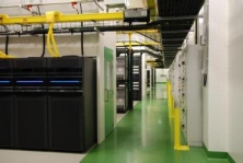 Lång korridor i ett datacenter upplyst av jämnt fördelade, energieffektiva PROLJUS-armaturer som framhäver serverrader och ger pålitlig, kostnadseffektiv arbetsbelysning från PROLJUS AB