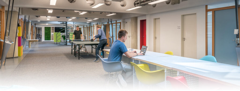 Öppet kontorslandskap upplyst av moderna rektangulära infällda LED-armaturer i taket som skapar jämnt, bländfritt arbetsljus, upptäck PROLJUS AB:s energieffektiva och designade armaturer som förbättrar fokus, trivsel och sänker driftkostnader