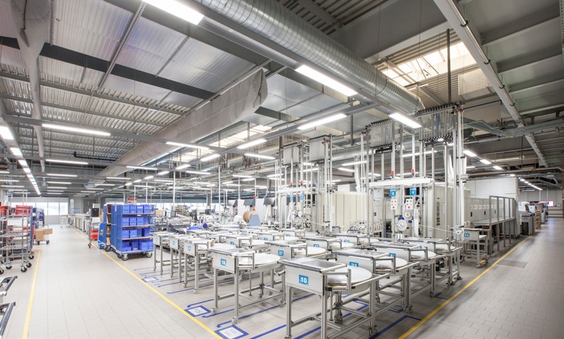 Ljust fabrikslokal med långa linjära pendelarmaturer från PROLJUS AB som sprider jämnt, energieffektivt LED-ljus över produktionsytan och förbättrar arbetsmiljö, säkerhet och produktivitet