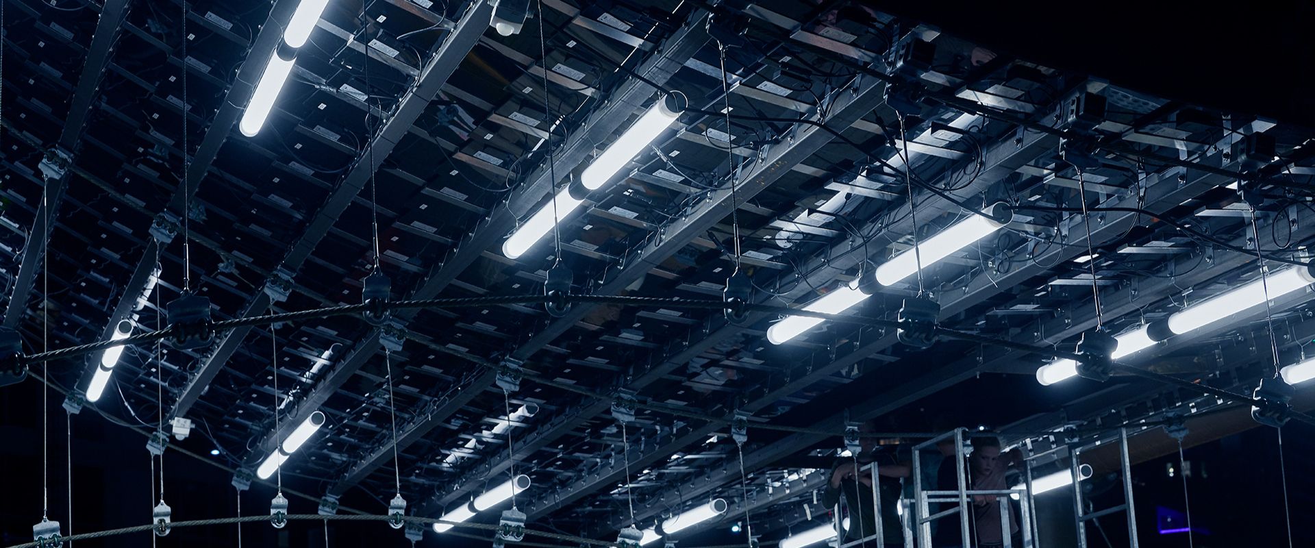 Detaljbild av flera hängande LED-armaturer i kallvitt ljus monterade i ett robust ställverk, visar PROLJUS ABs energieffektiva och professionella belysningslösningar för scen, event och industri