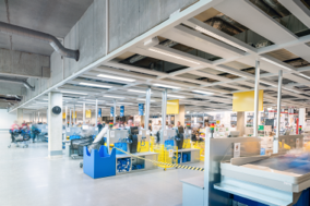 Stor butikslokal med takgaller och jämnt fördelade infällda LED-paneler som ger klart, energieffektivt arbetsljus och framhäver varor, belysningslösningar från PROLJUS AB för modern, kostnadseffektiv butiksmiljö