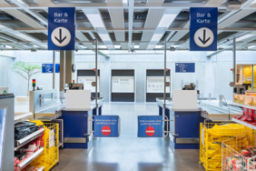 Moderna takarmaturer från PROLJUS AB ger jämnt, energieffektivt vitt ljus över en kassazon i ett varuhus, framhäver skyltar och produkter, ökar synlighet och försäljning och skapar en inbjudande professionell butiksmiljö