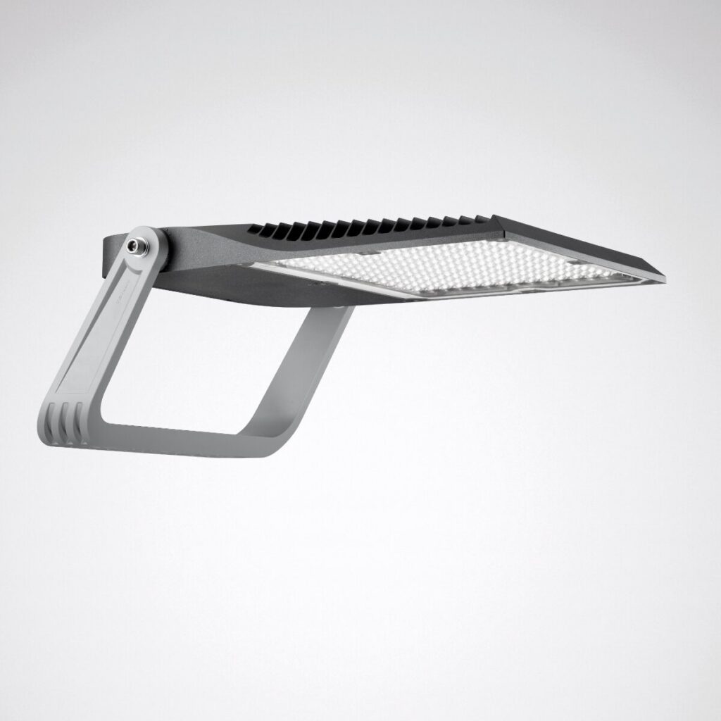 Smal, robust LED-armatur från PROLJUS AB med justerbart U-fäste, integrerade kylflänsar och optisk linsmatris som ger kraftfullt, jämnt och energieffektivt ljus, perfekt för sportarenor, industrilokaler och utomhusbelysning