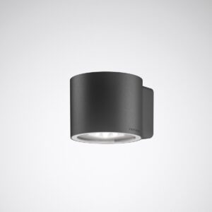 Mörkgrå cylindrisk väggarmatur i pulverlackerad metall med nedåtriktad LED-lins, energieffektiv och högkvalitativ minimalistisk design för entréer och fasadbelysning, säljs av PROLJUS AB