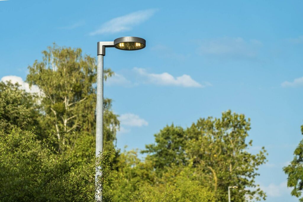 Modern och stilren LED-gatlykta från PROLJUS AB i parkmiljö, rund armatur som ger jämnt varmt ljus, energieffektiv och robust konstruktion med enkel installation för kommuner och bostadsområden
