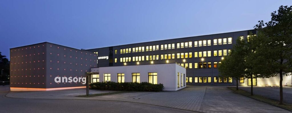 Kvällsbild av kontorsbyggnad belyst av armaturer från PROLJUS AB med varmvitt fönsterljus, fasadpunktbelysning och diskreta markljus som framhäver arkitekturen och säljer kvalitet för företagsbelysning