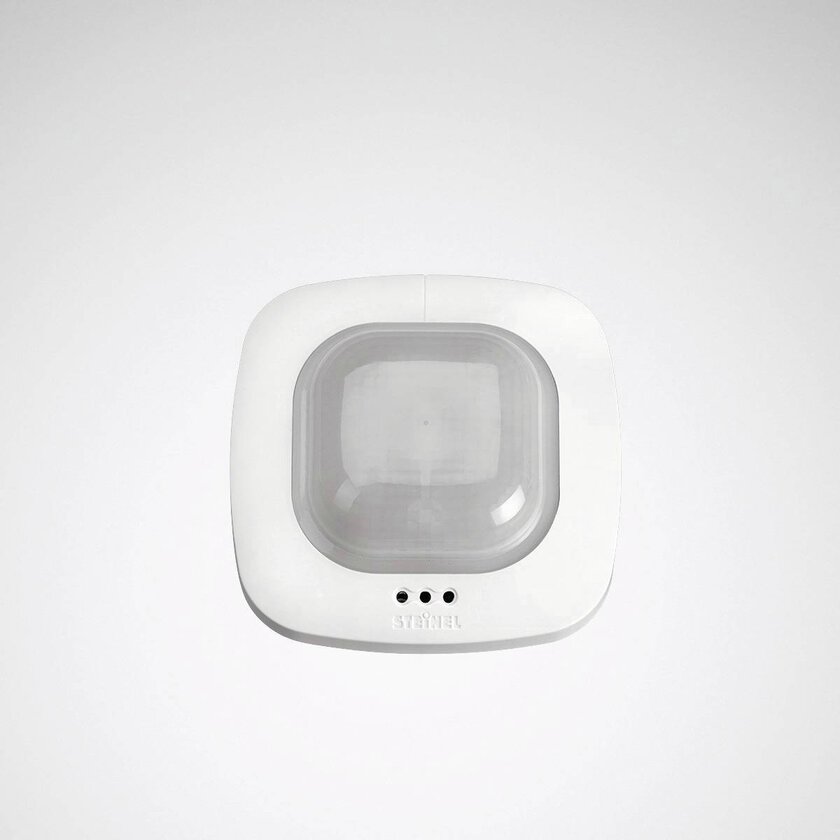 Vit takmonterad armatur med rundade kanter och frostad central kupol som döljer rörelse- och närvarosensor, stilren och energieffektiv lösning som säljs av PROLJUS AB