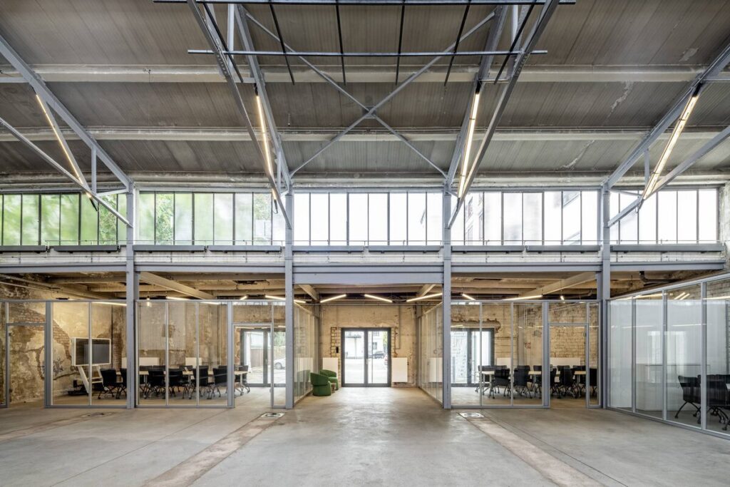 Interiör i industrilokal upplyst av moderna upphängda linjära LED-armaturer från PROLJUS AB som ger klart, energieffektivt och jämnt ljus över glasade mötesrum och framhäver industrikänslan i rummet