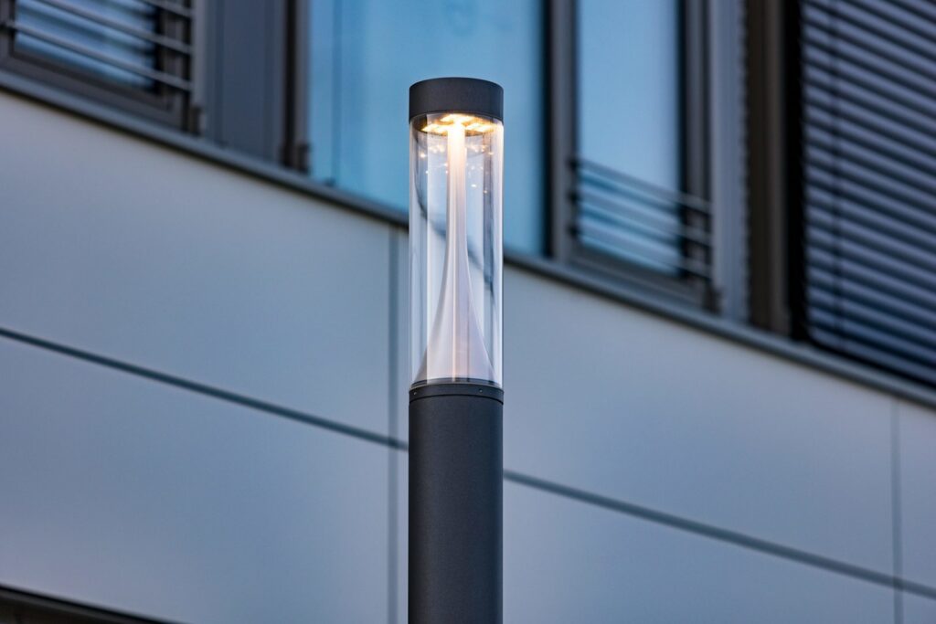 Modern pollare från PROLJUS AB med cylindrisk klar kupa och inre konformad diffusor som sprider ett varmt jämnt LED-ljus, elegant och hållbar lösning för entréer, gångstråk och företagsmiljöer