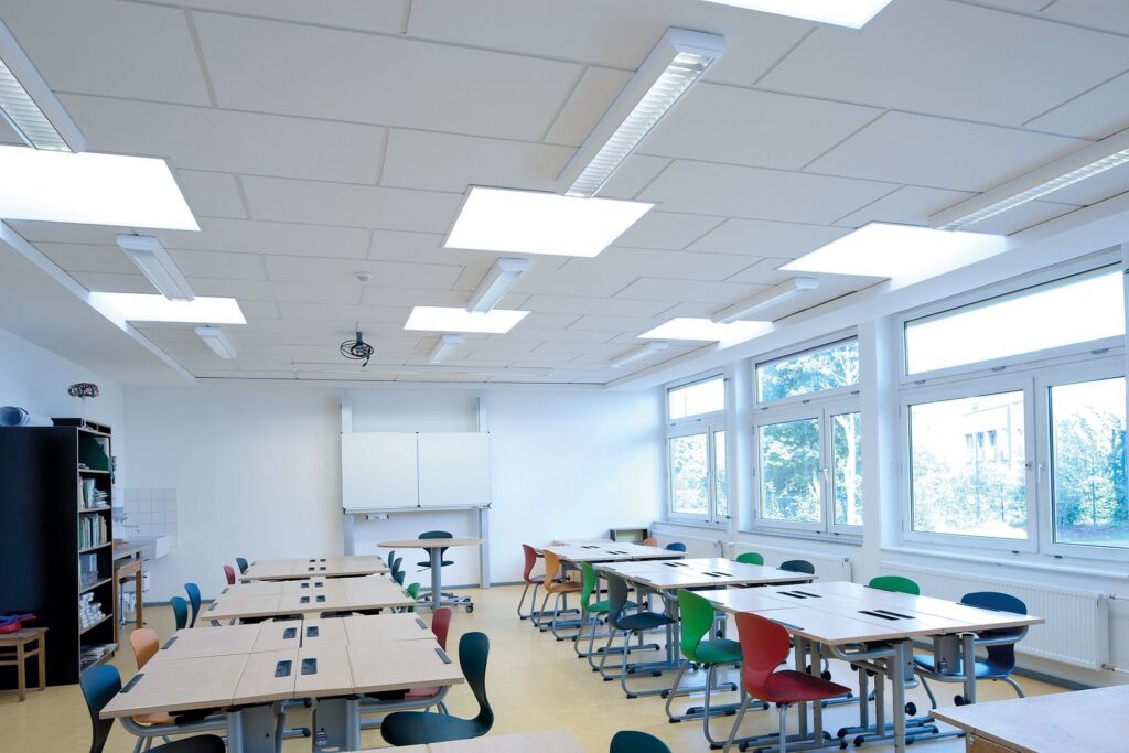 Takvy över ett ljust klassrum med jämnt bländfritt ljus från infällda kvadratiska LED‑paneler och linjära armaturer, energieffektiva och kostnadseffektiva lösningar för skolor och kontor från PROLJUS AB