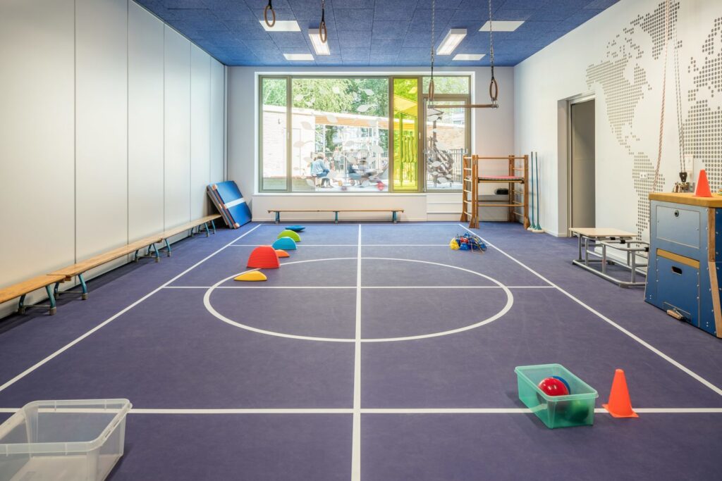 Snygga infällda LED-armaturer i akustiktak som ger jämn, bländfri belysning i gymnastiksal och skolfritidsrum, PROLJUS AB levererar energieffektiva, skräddarsydda belysningslösningar för trygga och trivsamma inomhusmiljöer