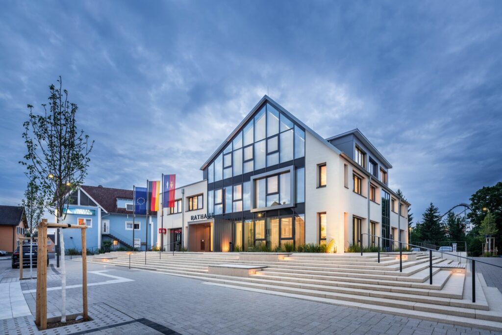 Kvällsbild av stadshus med varm fasad- och trappbelysning från PROLJUS AB som framhäver arkitekturen, markerar infällda steg och skapar en trygg energieffektiv entré