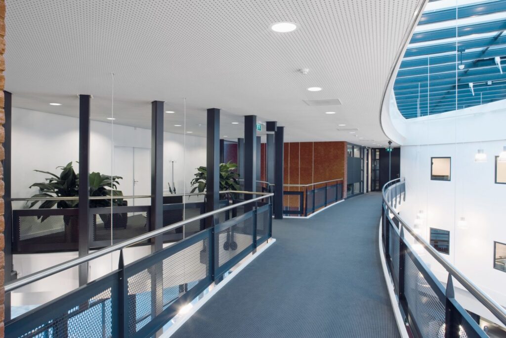 Ljust kontorsutrymme upplyst av infällda LED-armaturer och dekorativa hänglampor som visar PROLJUS AB:s energieffektiva och eleganta belysningslösningar