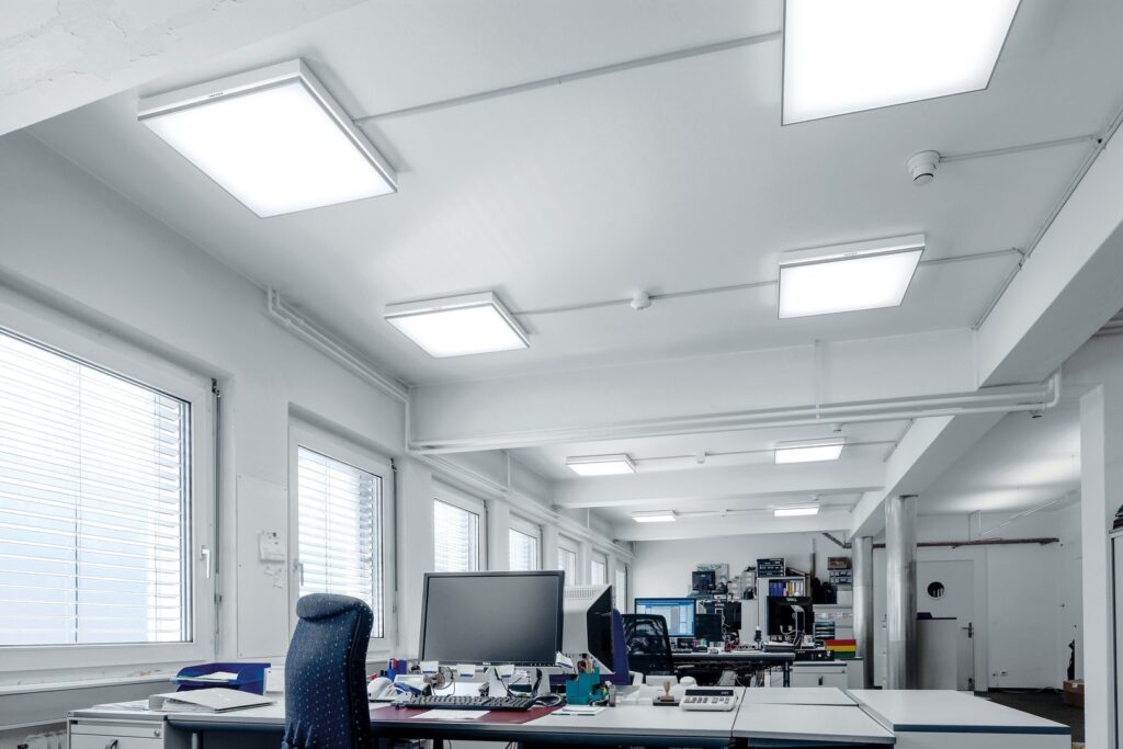 Öppet kontorslandskap upplyst av släta kvadratiska LED-takarmaturer som levererar jämnt, bländfritt och energieffektivt arbetsljus för produktiva arbetsplatser från PROLJUS AB