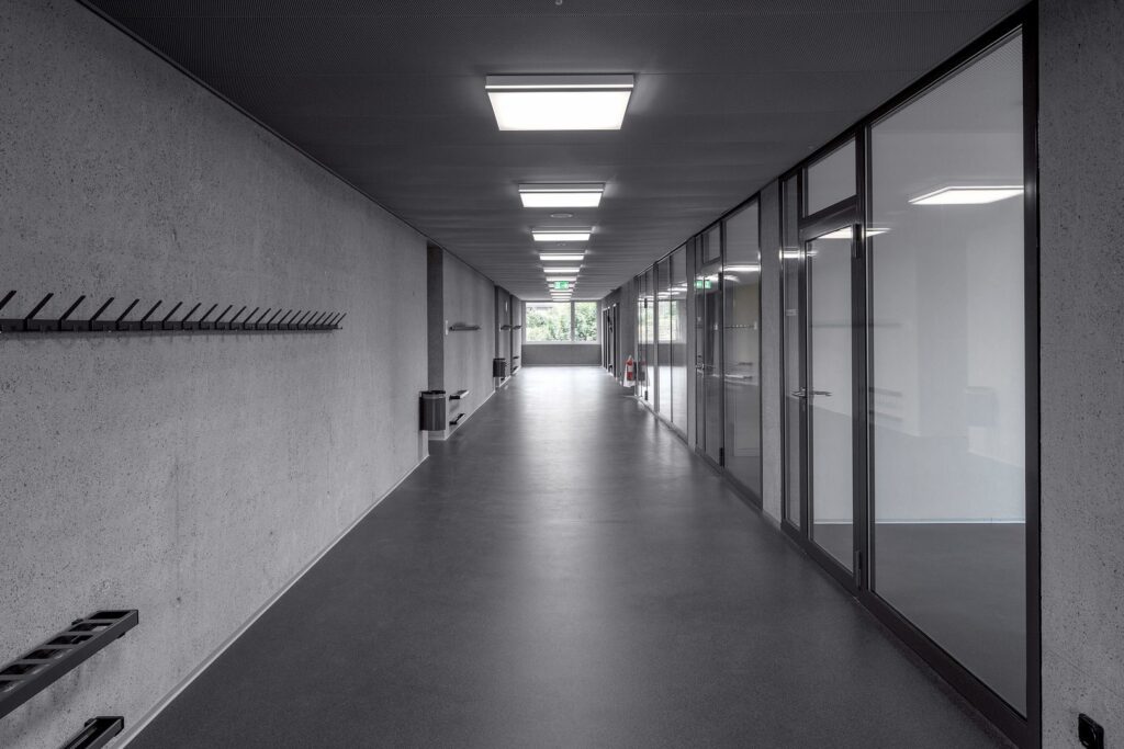 Modern korridor belyst av PROLJUS AB:s kvadratiska takarmaturer som levererar jämnt, energisnålt och behagligt arbetsljus med stilren design och lång livslängd