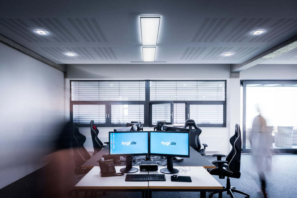 Kontorslandskap upplyst av PROLJUS ABs moderna takarmaturer med en rektangulär centrallampa och infällda spotlights som ger jämn, energieffektiv och bländfri arbetsbelysning och lyfter inredningen