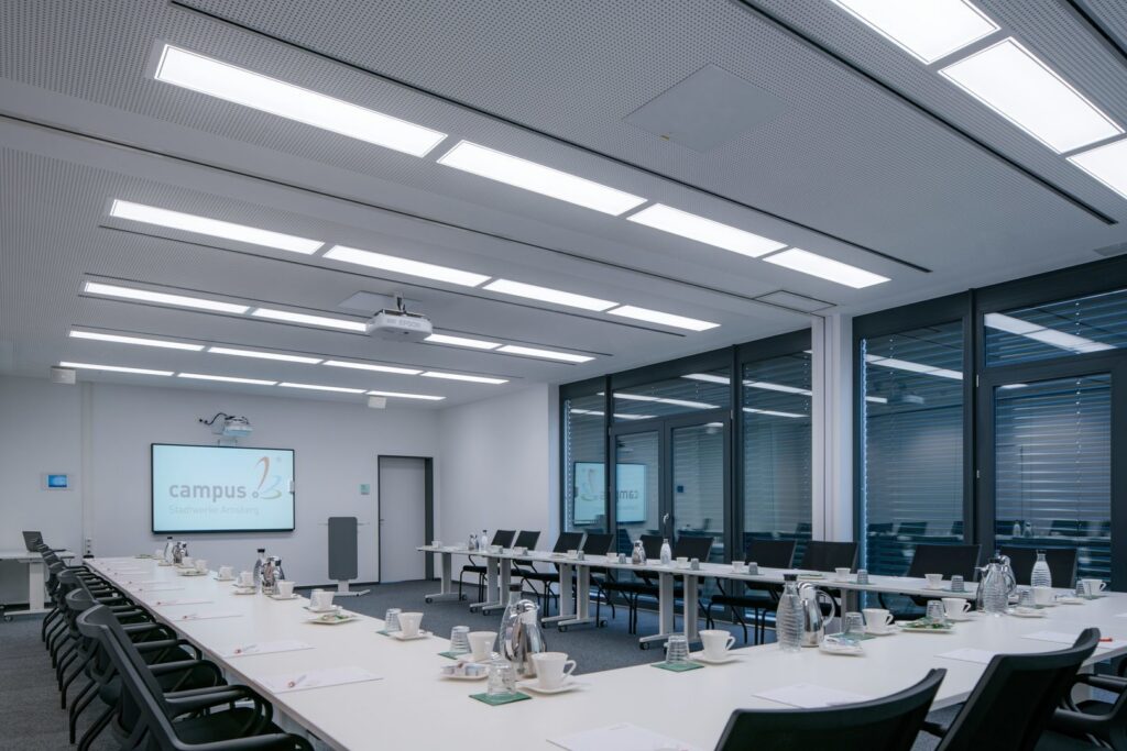 Konferensrum med jämnt fördelade rektangulära LED-armaturer i taket som ger bländfri, energieffektiv och jämn arbetsbelysning över bordet, ett tydligt exempel på PROLJUS AB:s högkvalitativa armaturer för kontor och mötesrum