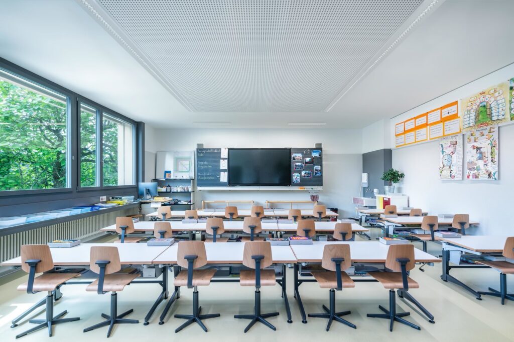 Modernt klassrum med slimmade infällda LED‑armaturer i takets perforerade akustikpaneler som ger jämnt, bländfritt och energieffektivt arbetsljus från PROLJUS AB perfekt för pedagogiska miljöer