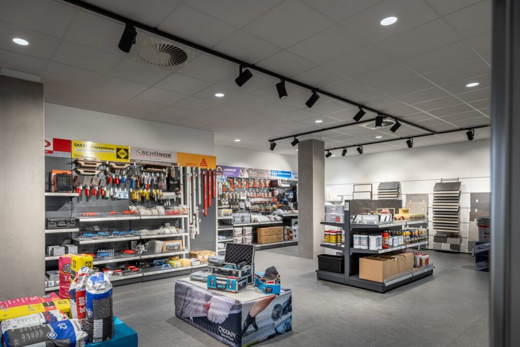 Butiksinteriör med moderna takarmaturer från PROLJUS AB, svarta riktbara skenspots och infällda downlights som ger jämnt energieffektivt ljus över hyllor och produkter, perfekt för butik och showroom, kontakta PROLJUS AB för köp och installation