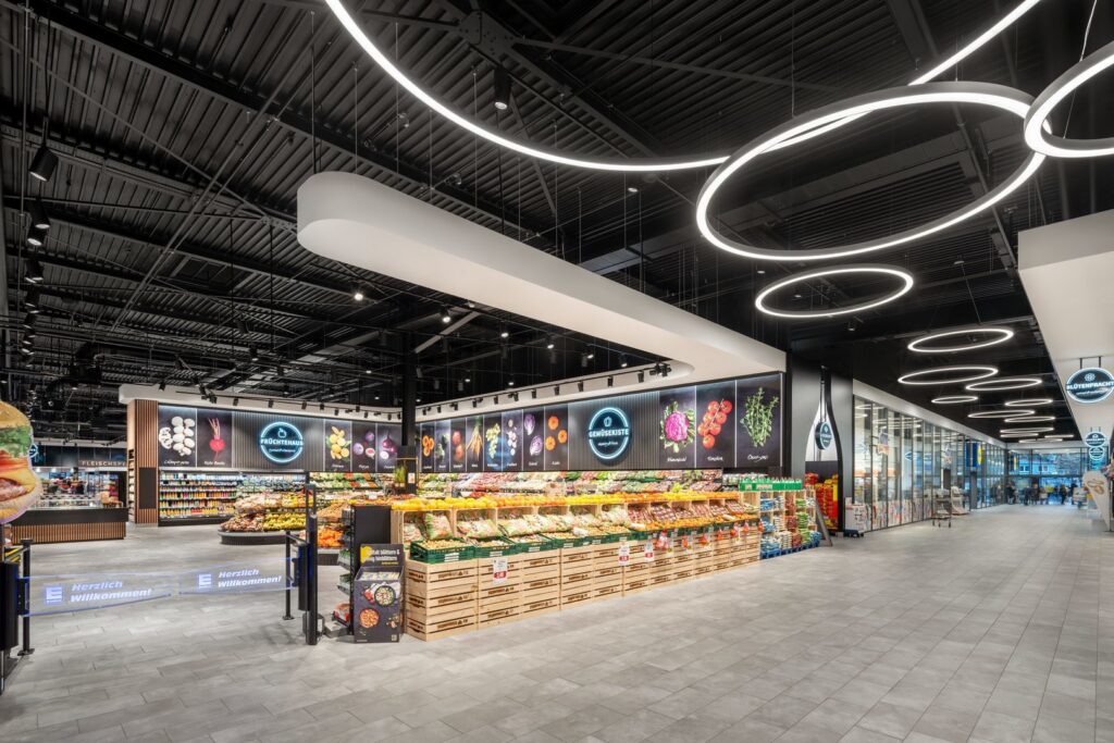 Stilrena LED-ringarmaturer i varierande storlekar och en lång, svepande linjär pendel över frukt- och gröntafdelningen som framhäver färger, skapar en inbjudande köpupplevelse och visar PROLJUS ABs energieffektiva belysningslösningar för detaljhandel