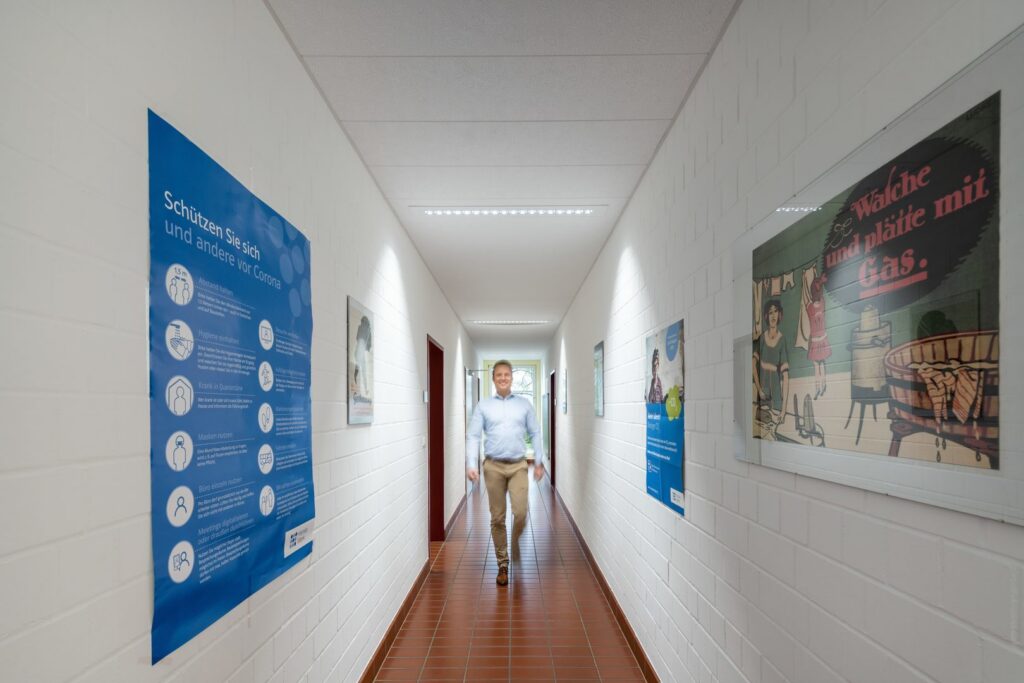 Lång vit korridor upplyst av jämnt fördelade slimmade LED-armaturer i innertaket som ger bländfritt och energisnålt ljus och en inbjudande arbetsmiljö perfekt för kontor och korridorer välj PROLJUS AB för högkvalitativa lättinstallerade takarmaturer och energieffektiva belysningslösningar