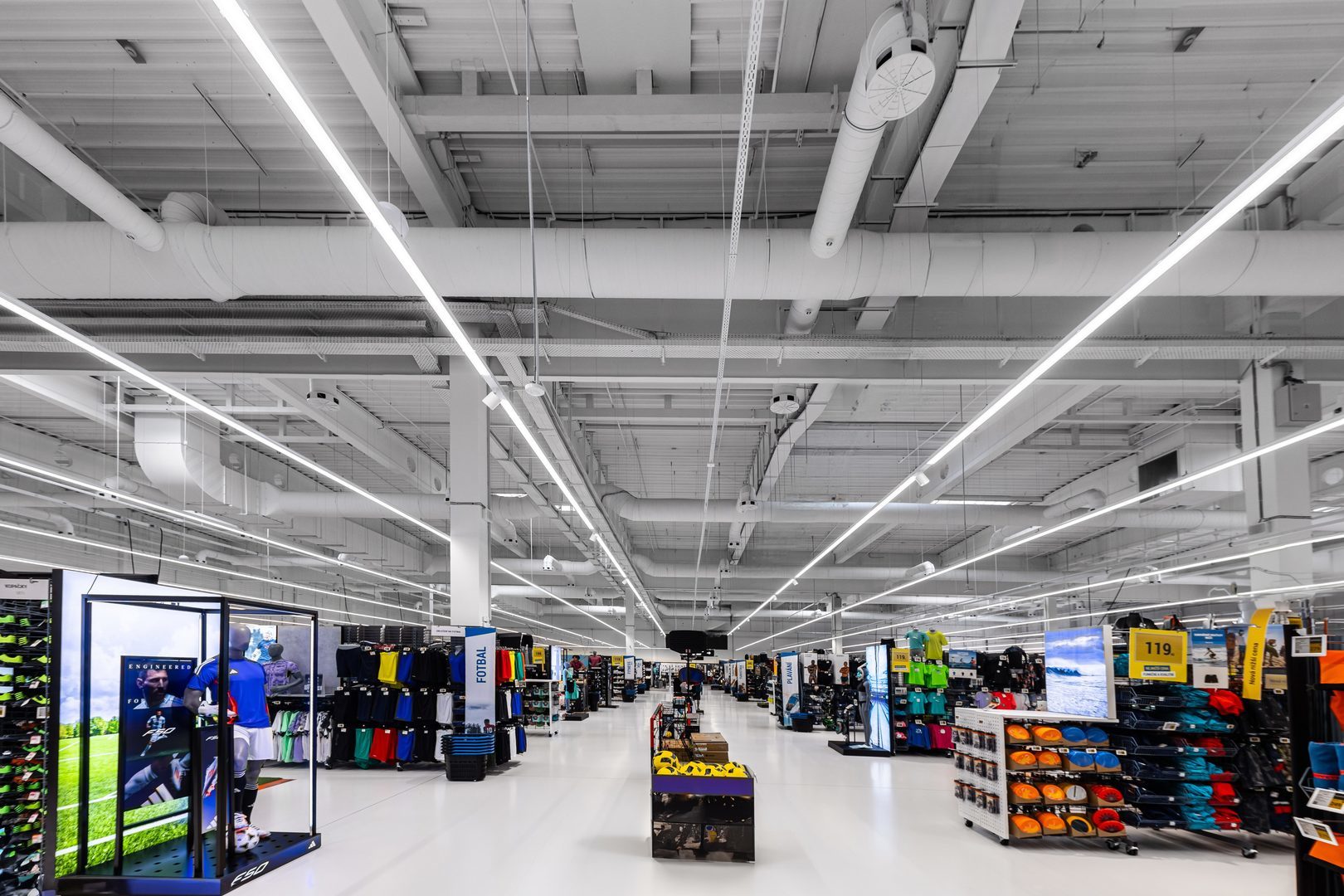 Stort varuhus med slanka linjära LED-armaturer från PROLJUS AB i taket som ger jämn, bländfri och energieffektiv belysning för förbättrad produktexponering och kundupplevelse, kontakta PROLJUS AB för dina belysningsbehov