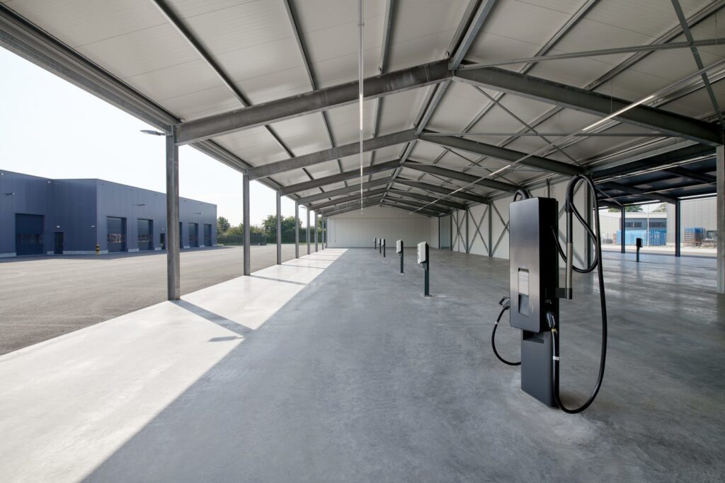 Öppen industripaviljong med PROLJUS ABs slimmade linjeluminärer monterade i takets mittgång, som ger jämn, energieffektiv LED-belysning, robust industridesign och enkel installation, idealisk för hallar, garage och logistikmiljöer