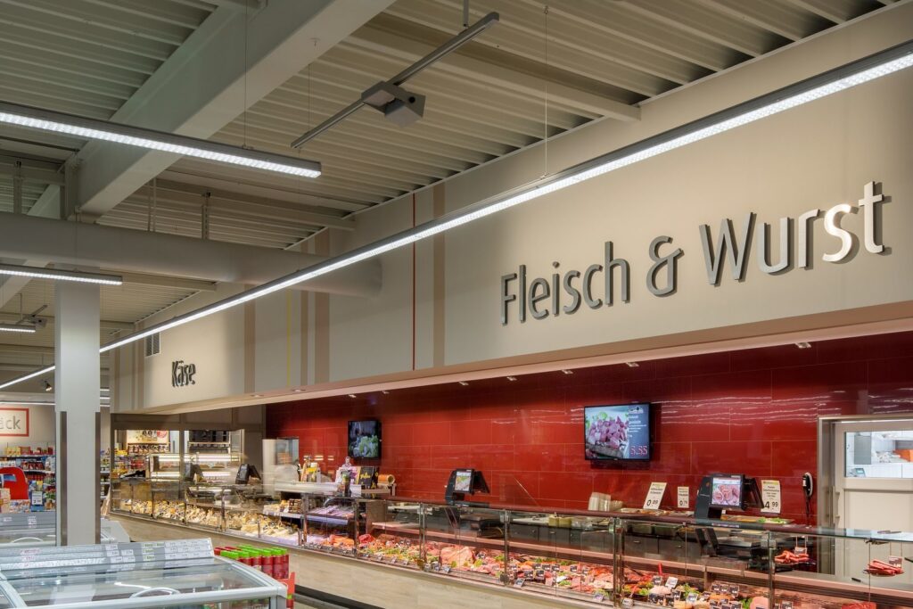 Takmonterade linjära LED-armaturer och skenor från PROLJUS AB som ger jämnt, energisnålt och reglerbart ljus över butikens kött- och delikatessdiskar och framhäver varorna för ökad försäljning