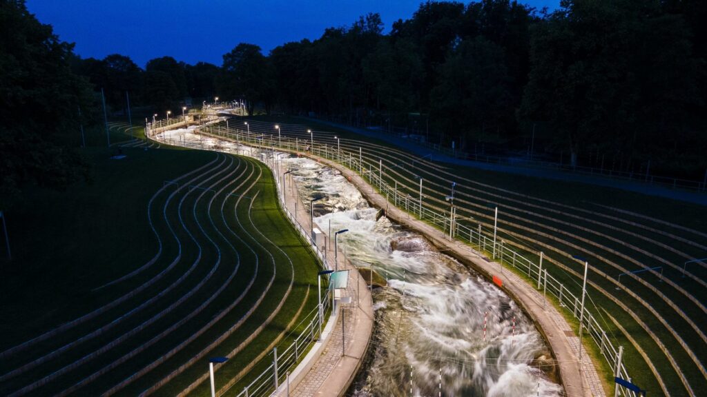 Nattvy över en upplyst fors med rader av armaturer från PROLJUS AB som levererar jämnt, energieffektivt och vädersäkert ljus för ökad säkerhet och bättre publikupplevelse i sport- och parkområden