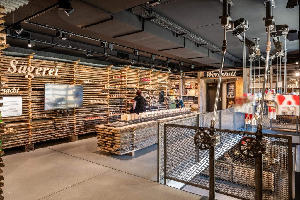 Svart takskenssystem med riktbara LED-spotlights och industridesignade armaturer som skapar varmt, riktat accentljus över trädisplayer och produkter, en energieffektiv och flexibel butikslösning som framhäver detaljer och ökar försäljningen, välj PROLJUS AB