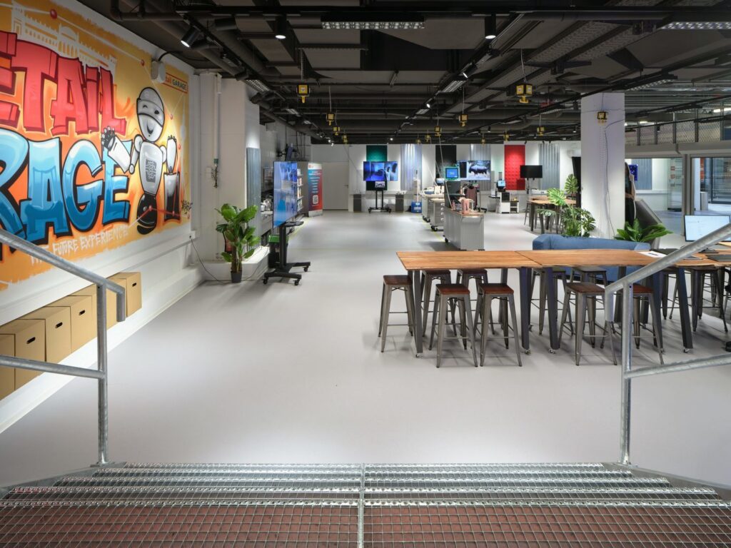 Modernt öppet kontorslandskap upplyst av PROLJUS ABs takarmaturer, svarta linjära LED-spottar och riktbara downlights som levererar jämnt bländfritt arbetsljus, energieffektivitet och stilren design perfekt för showroom och arbetsytor